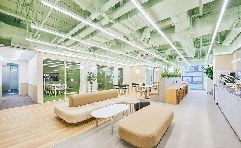 Spacious communal lounge at 366 Hangang-daero, Seoul Station with pale green ceilings and modern seating.