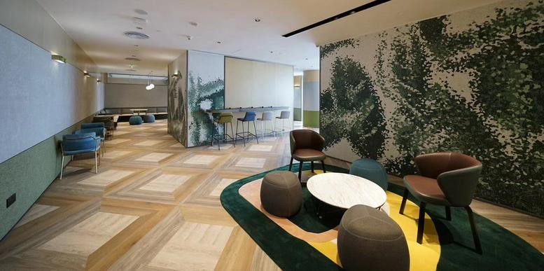 Spacious communal lounge at Tianying Plaza West Tower with feature mural, circular rug and stylish seating.