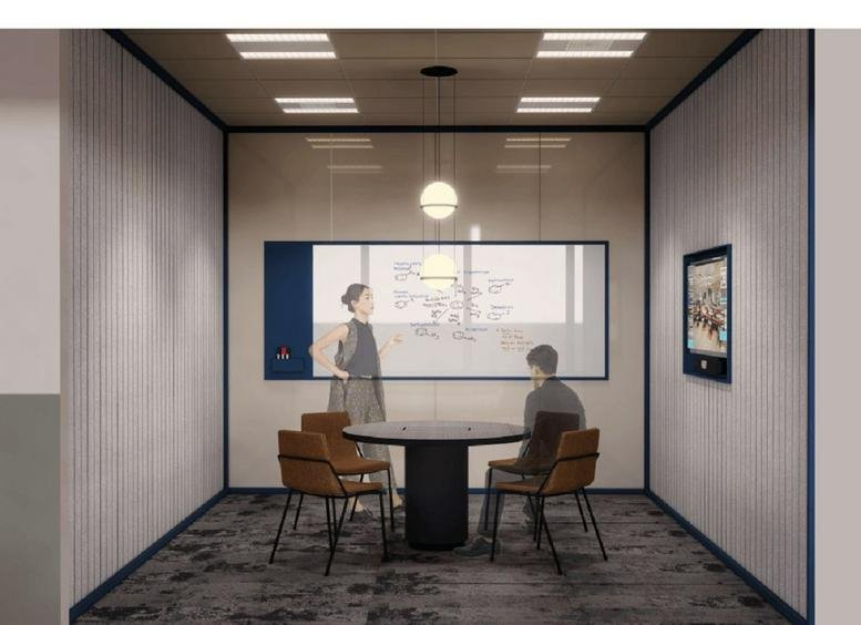 Small meeting room or focus pod with a round table, leather chairs, and a glass partition.