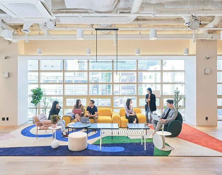 Spacious, brightly lit lounge area at 4-7F, 398, Seocho-daero with colorful rugs and comfortable sofas.