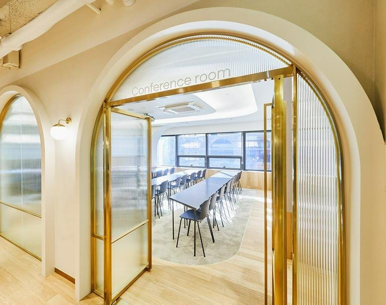 Arched gold-framed doorway leading into a bright conference room at 4, Eonju-ro 125-gil, Hakdong 1.