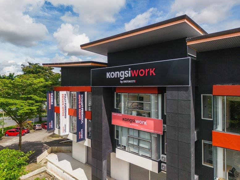Exterior facade of Kongsi Work By Infinity 8 with black and red branding under a blue sky.