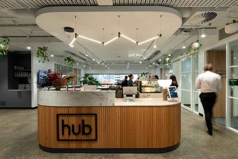 Modern wooden reception desk at 412 St Kilda Road, Level 12 with a branded logo and hanging plants.