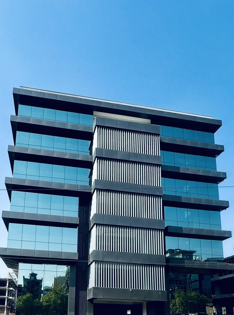 Exterior view of the modern glass-facade building at 43-A, IT Park, Sahastradhara Road, Dehradun.
