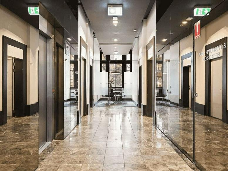 Long hallway at 430 Little Collins Street featuring reflective marble floors and mirrored walls.