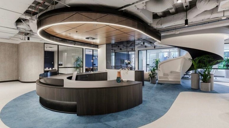 Professional reception area at 440 Collins Street featuring a curved dark wood desk and spiral staircase.