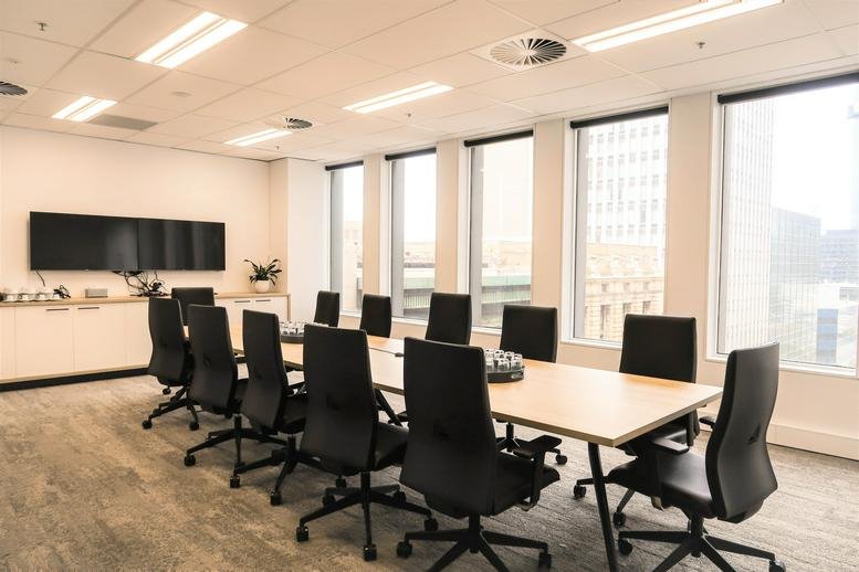 Large sunlit boardroom with black chairs and city views from Level 10, 440 Collins Street, Melbourne.