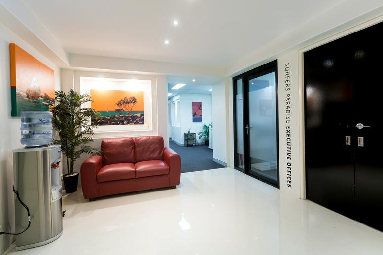 Bright reception area at Suite 46, Level 5, 46 Cavill Avenue with a red sofa and water cooler.