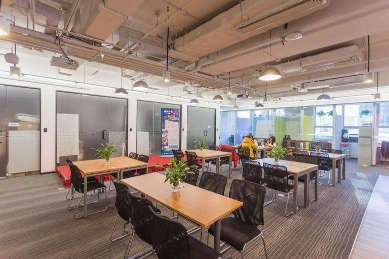 Spacious coworking area with wooden tables and plants at Borui Building.