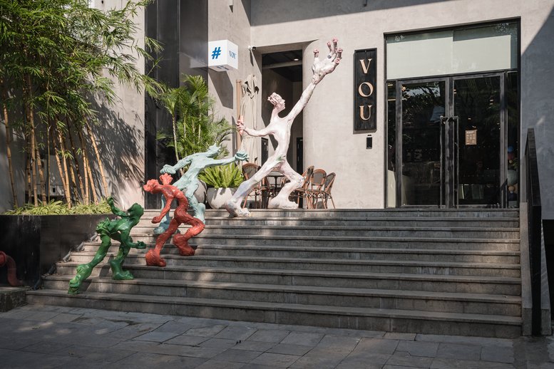 Exterior entrance of 51 Phan Boi Chau Street, Cua Nam Ward, Hanoi with colorful sculptures on steps.