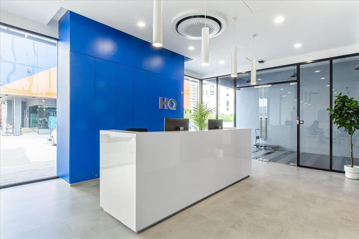 Modern reception area at 51 Sukhumvit 24 Alley with a white desk and a vibrant blue feature wall.