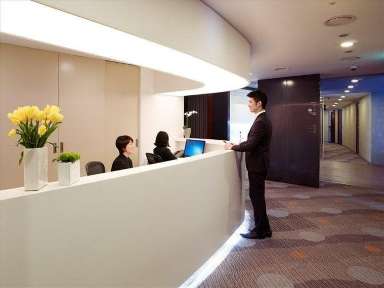 Bright, modern reception area of the ASEM Tower with a curved desk and yellow flowers.