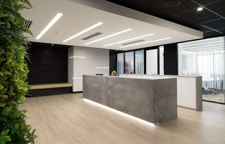 Modern reception lobby with stone-clad front desk and vertical garden wall at 52 McDougall Street.