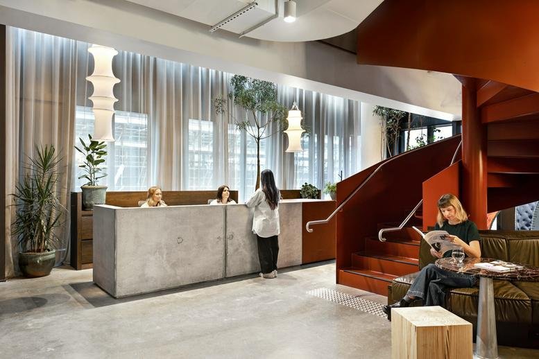 Reception and lobby area with concrete desk and spiral staircase at 54 Wellington Street, Collingwood.