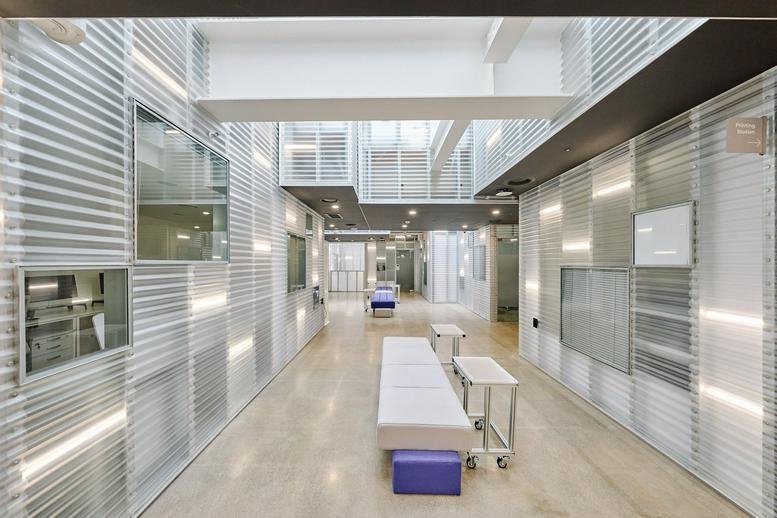Spacious corridor and lounge area at 55 Seongsuil-ro 8-gil, Seongsu 2, Seoul, South Korea with ribbed metal walls.