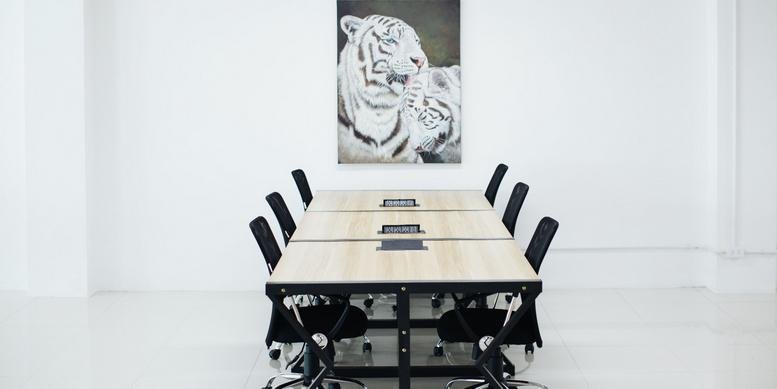 Spacious boardroom at 59 Chao Fah Tawan Tok Rd with a large wooden table and tiger artwork.