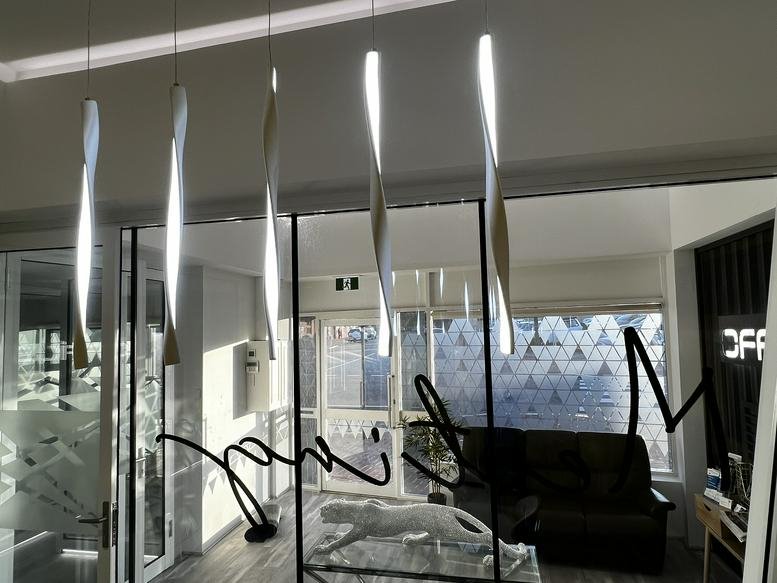 Glass wall with decorative privacy film and elegant pendant lighting.