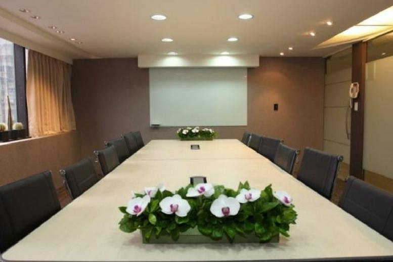 Large meeting room at 5F, No. 285, Section 4, Zhongxiao East. Rd, Dahan Dist with white orchids and a projector screen.