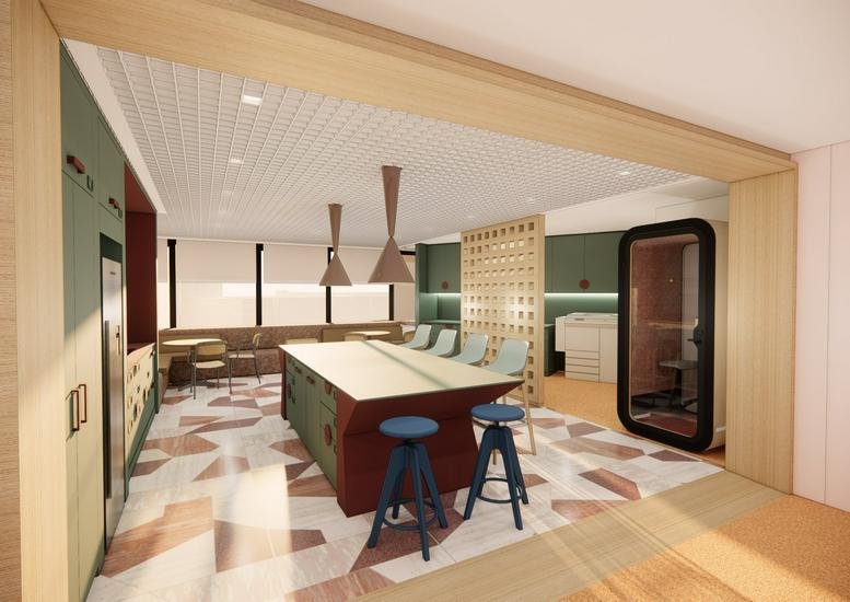 Spacious communal breakout area with a central island and colorful geometric carpet.