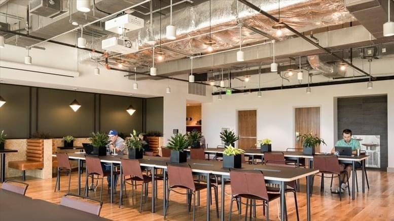 Spacious communal lounge at 608 Xikang Lu with industrial ceilings, long wooden tables, and warm lighting.