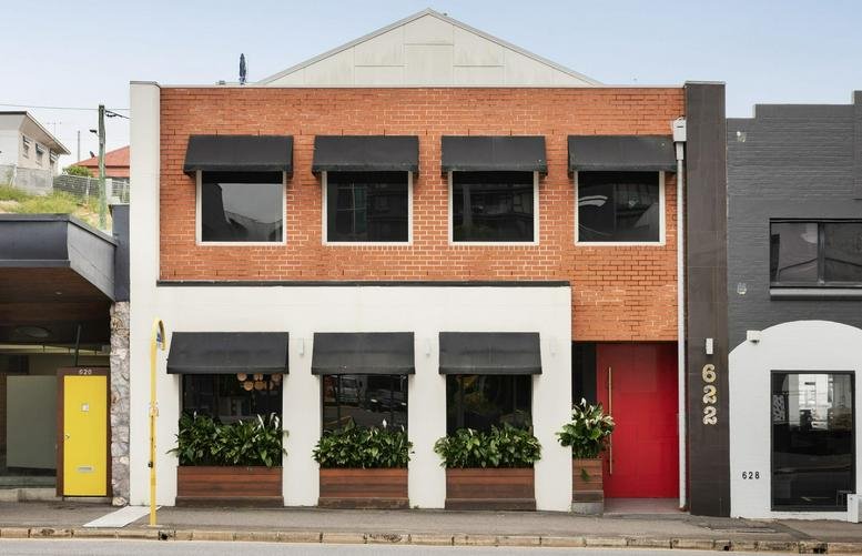 Street view of the two-story brick and white facade at 622 Wickham Street Brisbane.