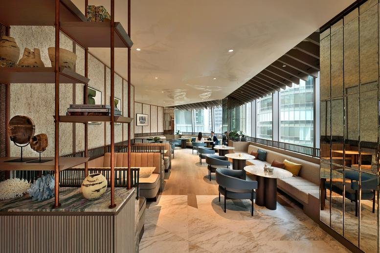 Spacious communal lounge at 63 Robinson Road featuring floor-to-ceiling windows and cafe seating.