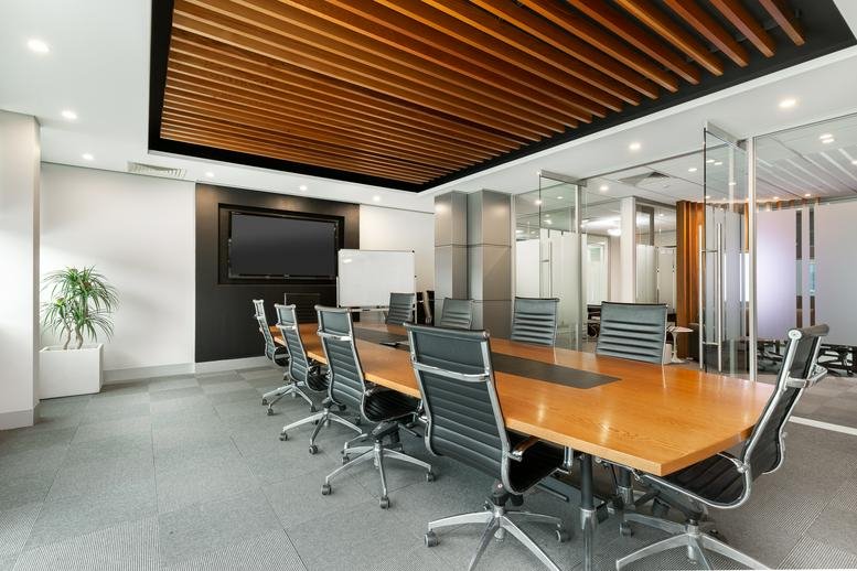 Spacious boardroom at 64, Victor Crescent, Level 1, Melbourne with wood-slat ceiling and large meeting table.