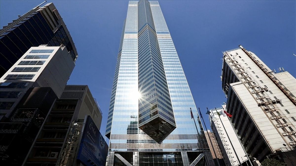 Looking up at the glass facade of The Center building under a clear blue sky.