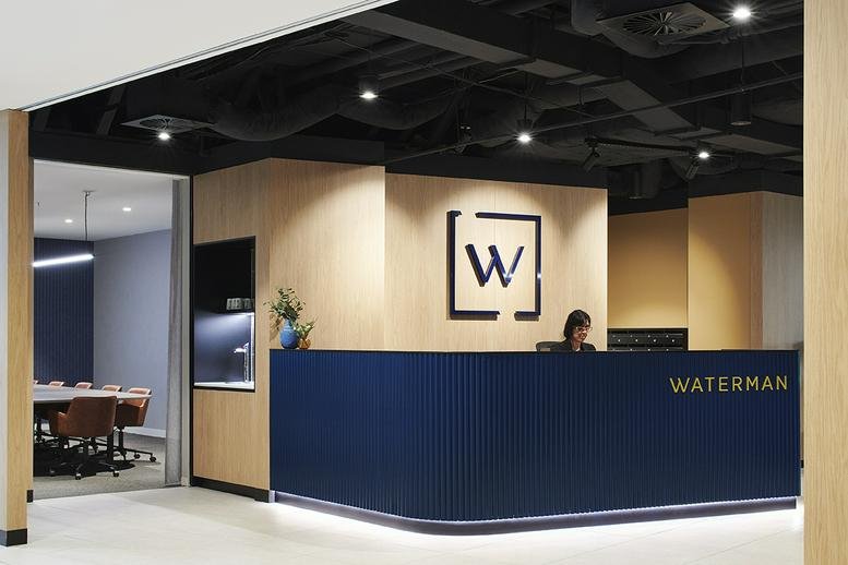 Modern branded reception area at 678 Victoria Street, Richmond, Melbourne with a navy blue desk and wood paneling.