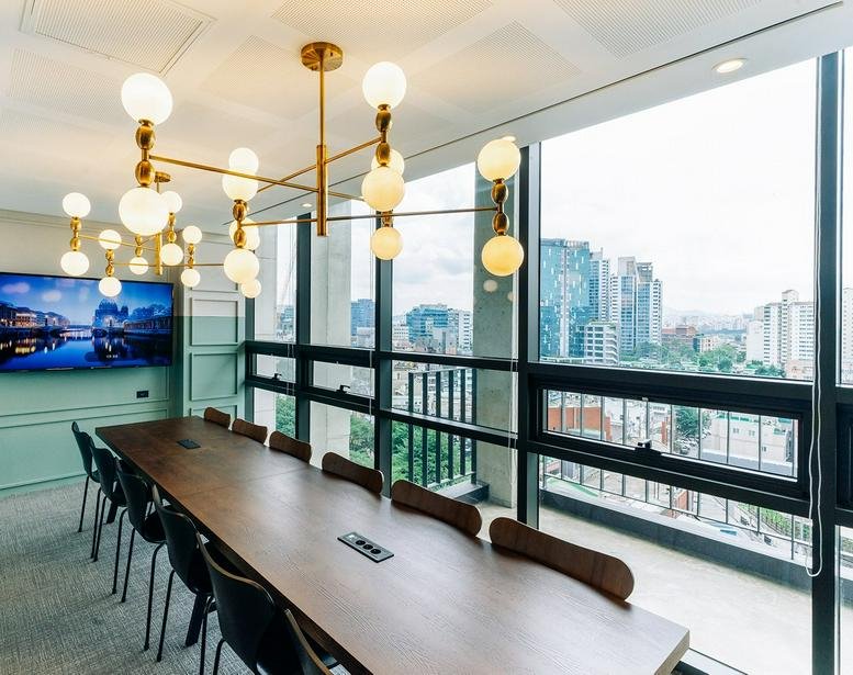 Spacious meeting room at 68, Achasan-ro, Seoungsu 1 with a long wooden table and city views through large windows.