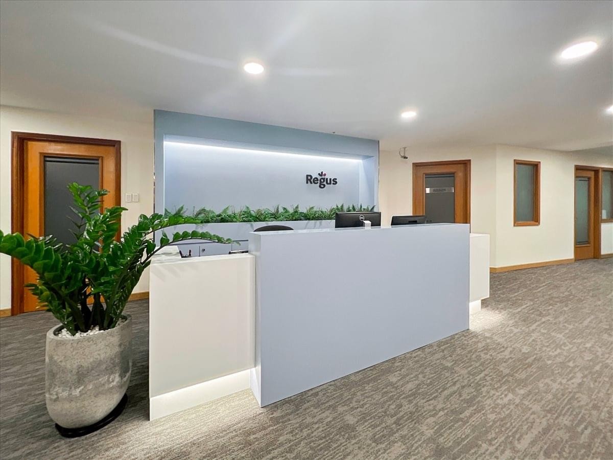 Sleek minimalist reception desk with blue accents and wooden doors.