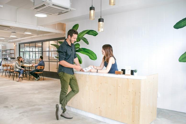 Bright reception desk at 7/F Cheung Hing Industrial Building with a wooden counter and indoor plants.