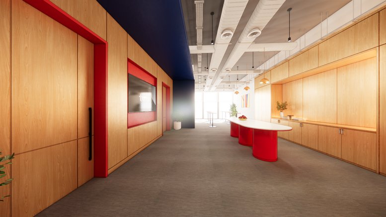 Open breakout area at 7 Science Park Drive featuring a long red table and wood cabinetry.