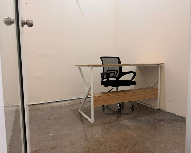 Minimalist private office suite featuring a white-framed desk and an ergonomic mesh chair.