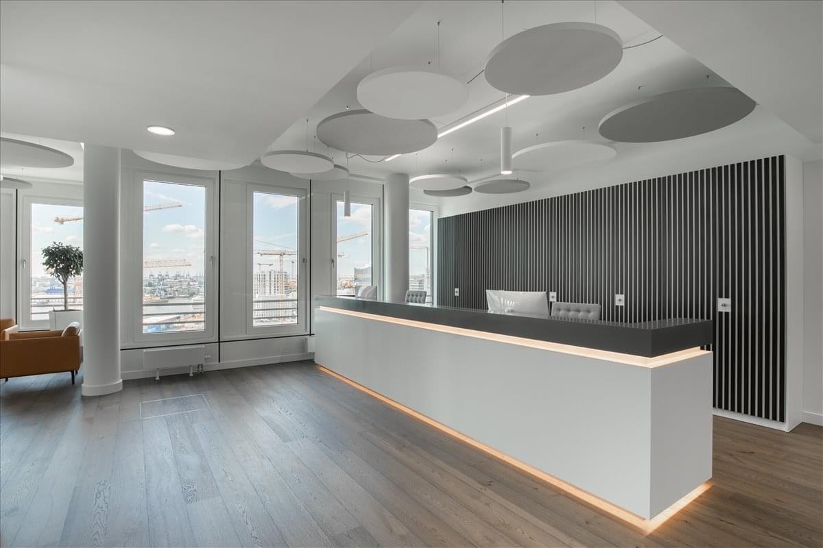Bright reception area at Gran Green Osaka Gate Tower with a white desk and circular acoustic ceiling panels.