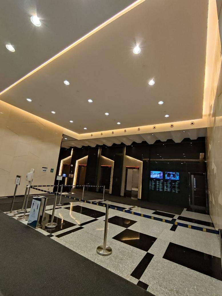 Spacious modern lobby with warm ceiling lighting and patterned flooring.