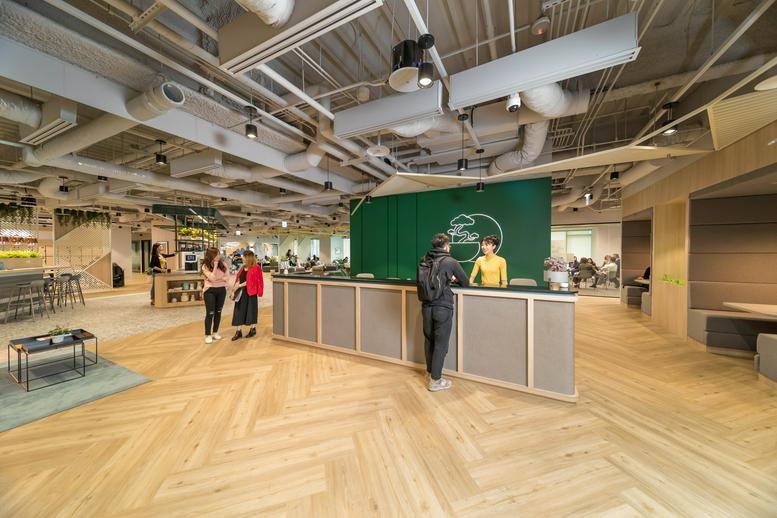 Spacious reception area at Minsheng Jianguo with wooden floors and a green feature wall.