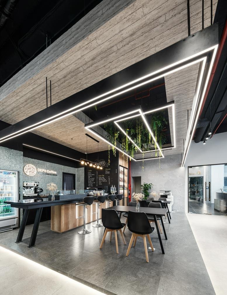 Stylish communal cafe area at 8 Ta Quang Buu Street with wood accents and linear lighting.