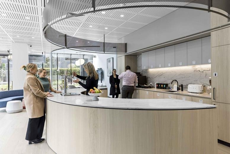 Spacious reception area at 80 Dorcas Street with a curved light wood counter and modern kitchen facilities.