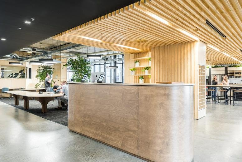 Reception area at 80 Market Street, South Melbourne featuring a curved wood desk and slatted timber ceiling.