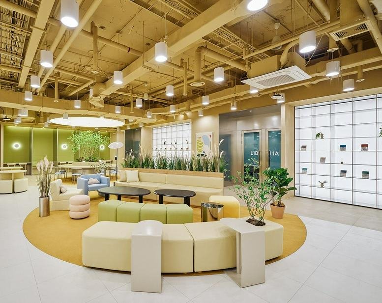 Spacious communal lounge with colorful seating and wood accents at 81, Yanghwa-ro, Mapo-gu, Seoul.