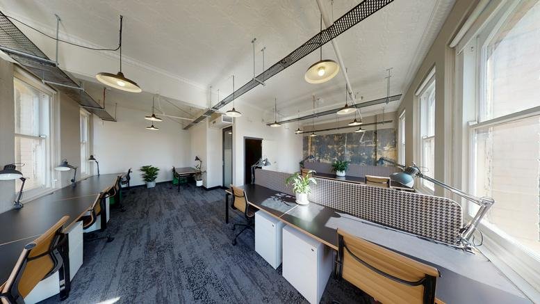 Bright, high-ceiling workspace at 822, George Street, Sydney, New South Wales with long wooden desks.