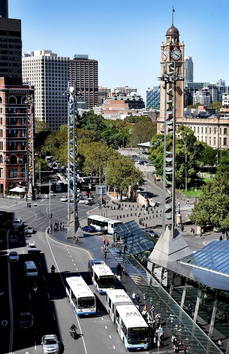 A bustling city street view of 822 George Street, Sydney, showcasing the historic clock tower and busy bus terminal.