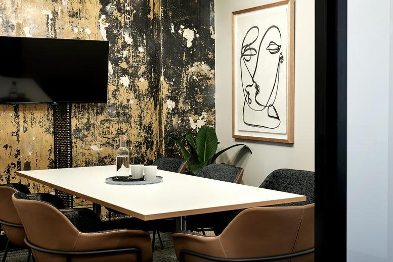 Bright meeting room at 822 George Street Sydney featuring a white table and abstract wall art.