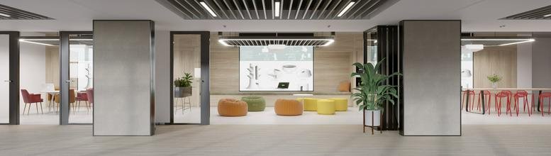 Bright communal lounge area with colorful ottomans and a slatted wood ceiling.