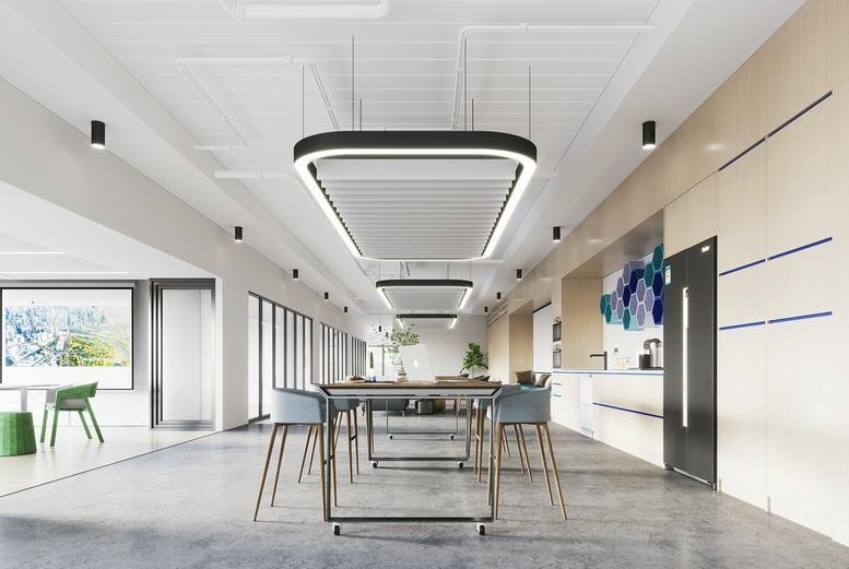 Modern breakout space with high tables, pendant lighting and a kitchen area.