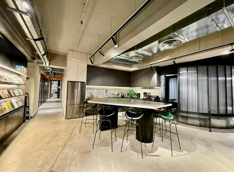 Communal break area at Shield Industrial Centre featuring a large island table and modern industrial design.