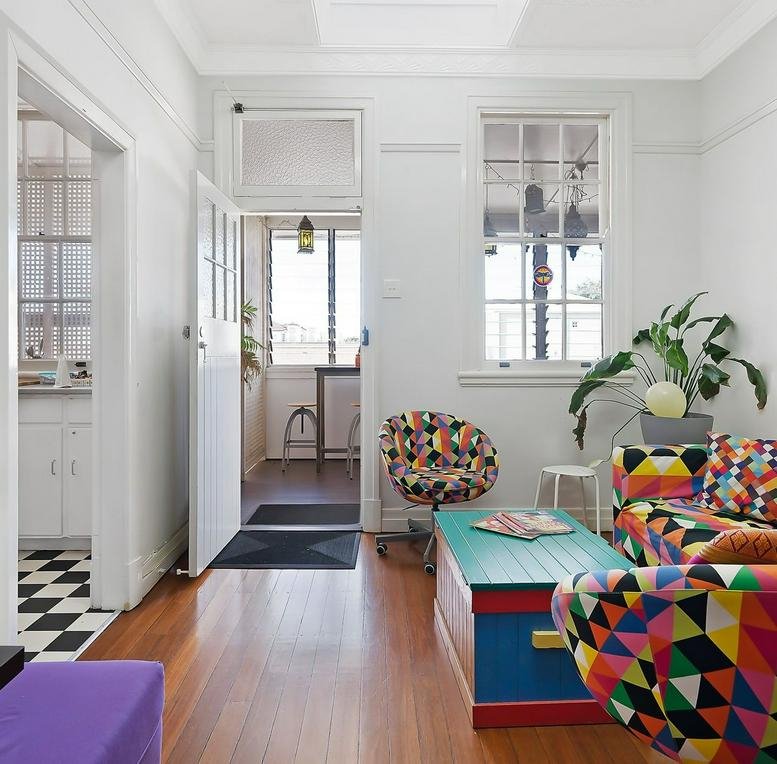 Colorful living area at Level 1, 888 Brunswick Street with geometric patterned sofa and teal coffee table.