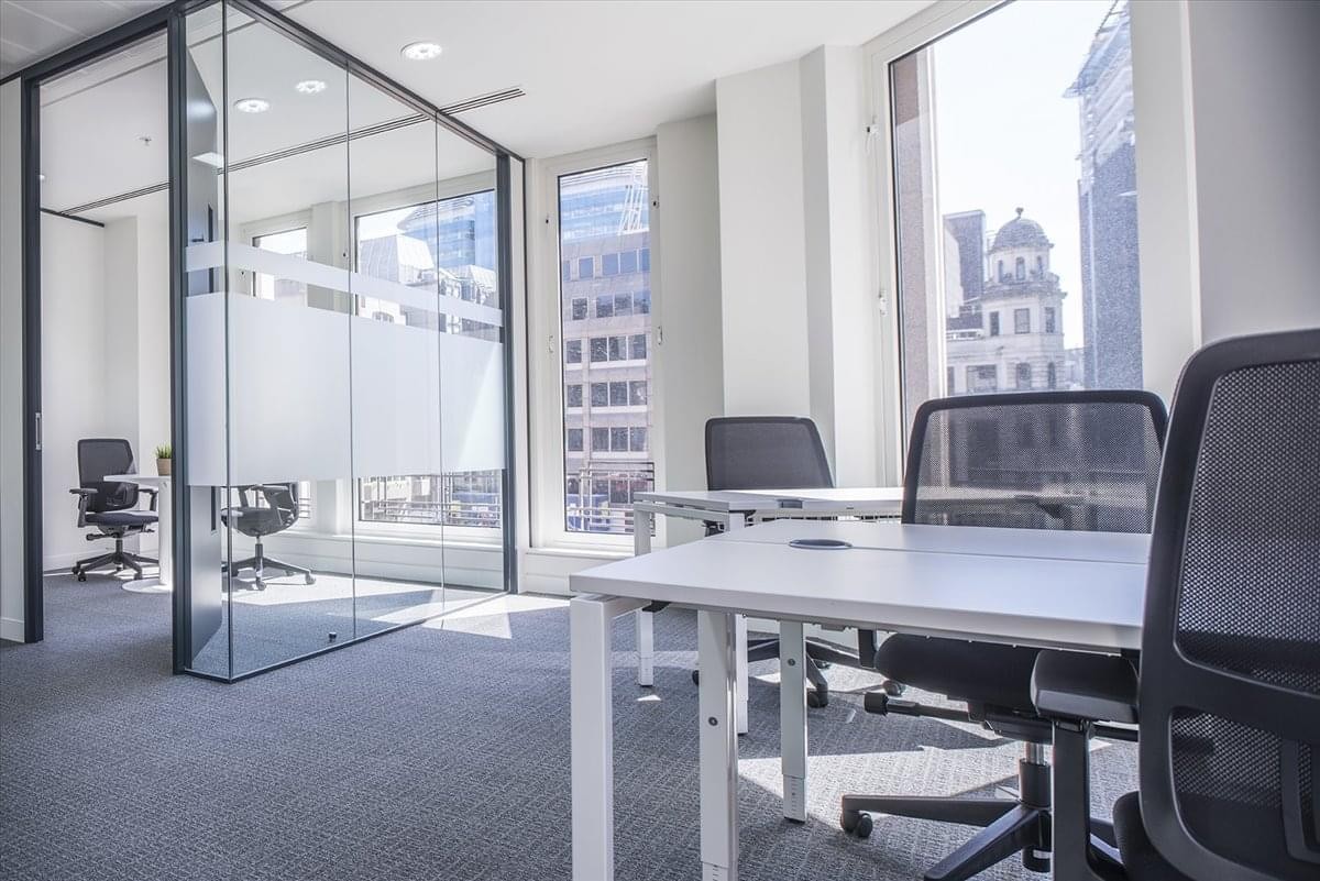 Spacious, well-lit coworking area with glass-walled offices at Hankyu Senri Chuo Building.