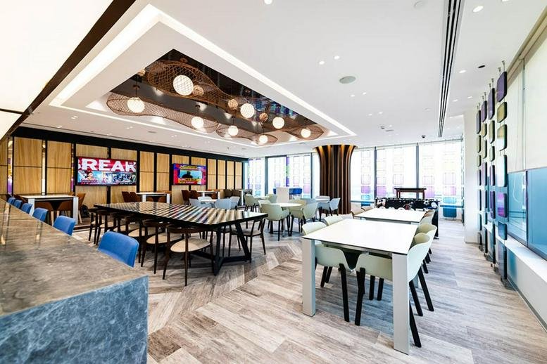 Spacious communal breakout area at Prestige Technostar, B3 Building featuring modern lighting and dining tables.